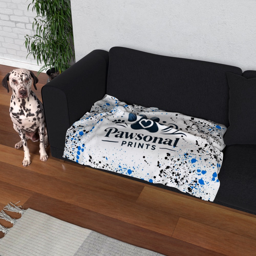 "Personalised pet blanket displayed on a sofa, featuring a custom design and company logo for branding."